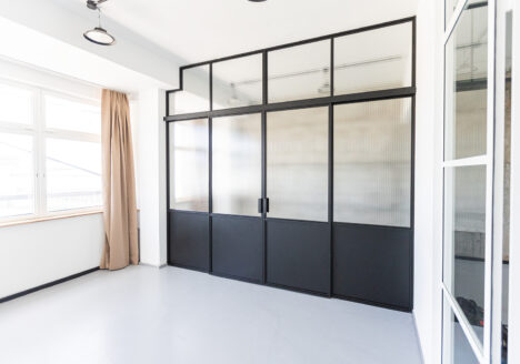 Stahl Lofttür für Gewerbe und Privat, Glastrennwand als Doppel-Schiebetür mit feststehenden Seitenteilen und Oberlicht, individuell hergestellt, Aufmaß und Montage in Berlin, maßgeschneiderter Raumtrenner aus Metall und Glas für Loft-Wohnzimmer und Arbeitsplätze, Aufmaß und Montage, Einbau in Berlin