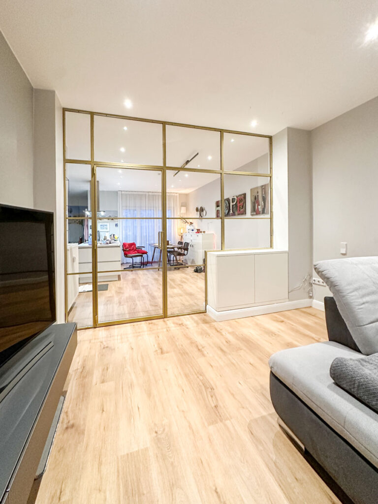 Stahl-Meister Slim Line Loft Tür, Glastrennwand mit goldenem Stahlprofil, Lofttür aus Stahl und Glas, mit Drehtür, Oberlicht und Seitenteil im Wohnzimmer und Küche