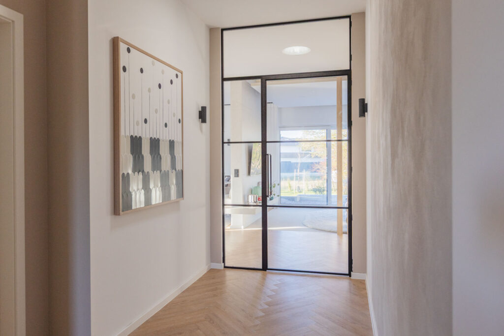 Stahl_Meister_Slim_Line_Lofttuer_Glastrennwand_Stahlrahmen_Glas_Drehtuer_Oberlicht_Seitenteil_Schwarz_826A3930 Stahl-Meister - günstige Slim Line Loft Tür, Glastrennwand mit Drehtür, Seitenteil und Oberlicht, schwarzem Stahlprofil, Lofttür aus Stahl und Glas, als Schallschutz und Wärmedämmung zwischen Flur und Wohnzimmer und Arbeitszimmer filigrane Tür mit RAL 9005 Tiefschwarz Stahlrahmen und Klarglas Glas