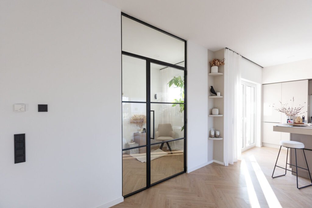 Stahl_Meister_Slim_Line_Lofttuer_Glastrennwand_Stahlrahmen_Glas_Drehtuer_Oberlicht_Seitenteil_Schwarz_826A3936 Stahl-Meister - günstige Slim Line Loft Tür, Glastrennwand mit Drehtür, Seitenteil und Oberlicht, schwarzem Stahlprofil, Lofttür aus Stahl und Glas, als Schallschutz und Wärmedämmung zwischen Flur und Wohnzimmer und Arbeitszimmer filigrane Tür mit RAL 9005 Tiefschwarz Stahlrahmen und Klarglas Glas