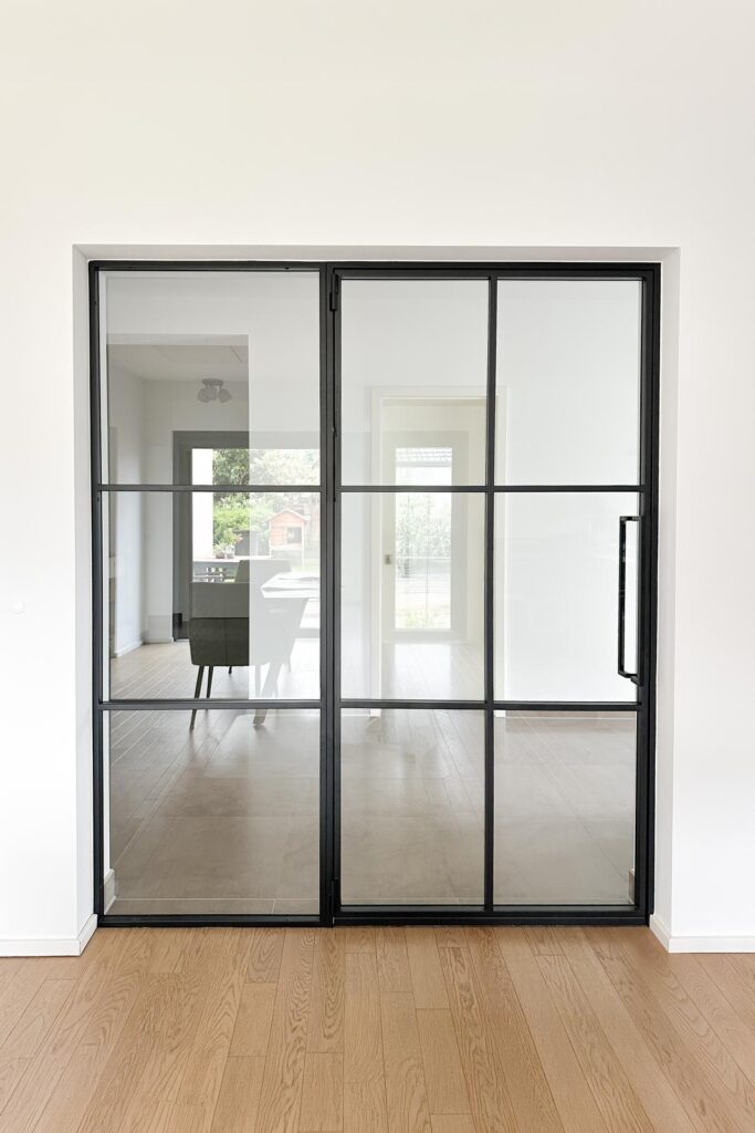 Stahl Meister Lofttür Slim Line GlastrennwandDrehtür mit Seitenteil in RAL9005 Tiefschwarz mit 8mm VSG Glas und absenkbare Bodendichutng